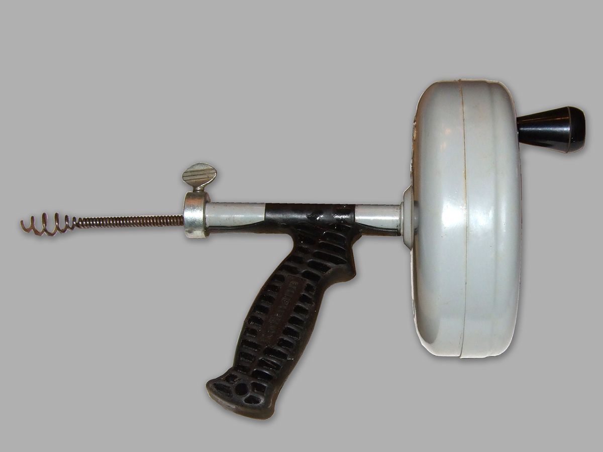 A handheld drain auger with a coiled cable