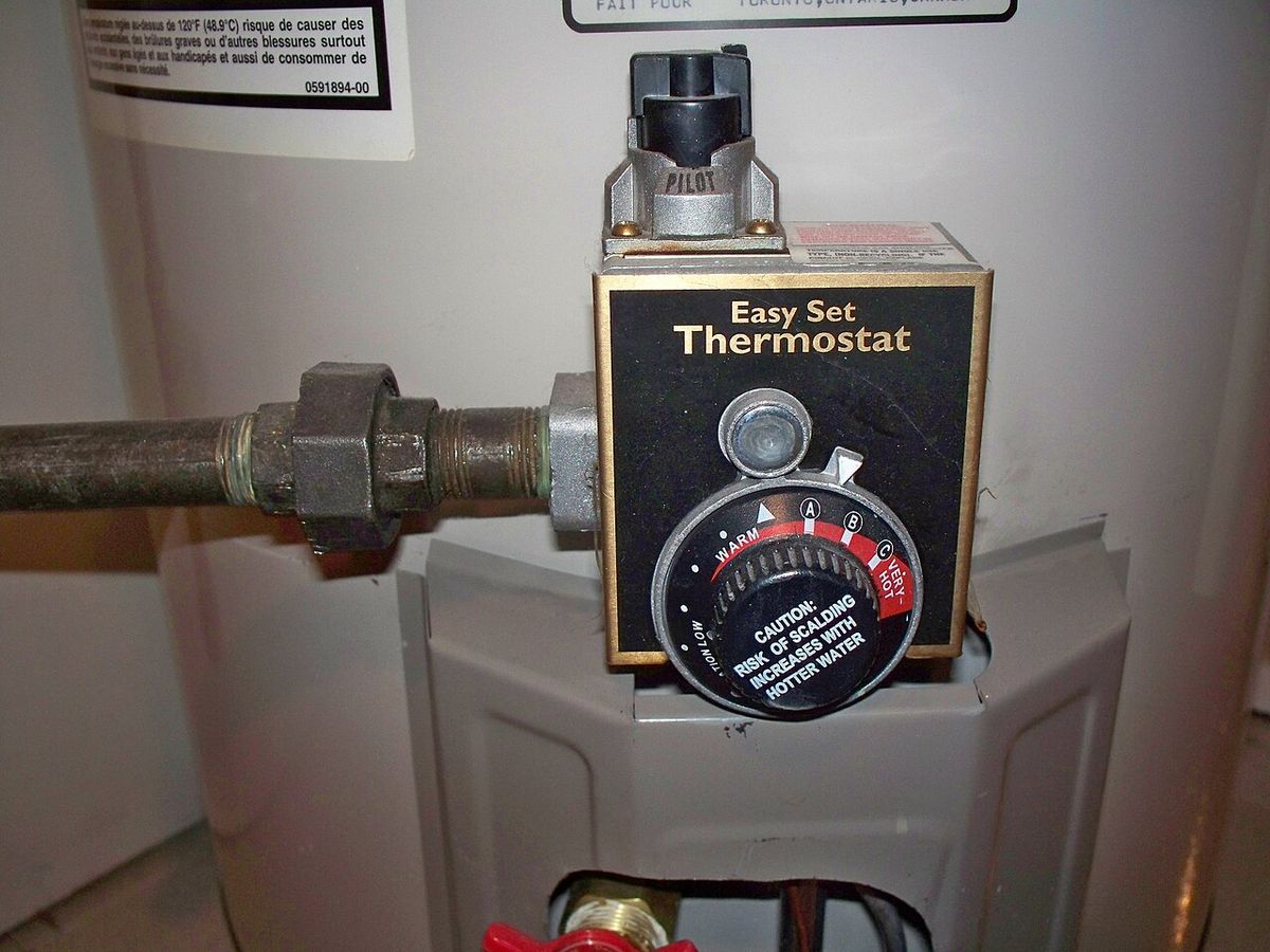 The thermostat dial on a gas water heater