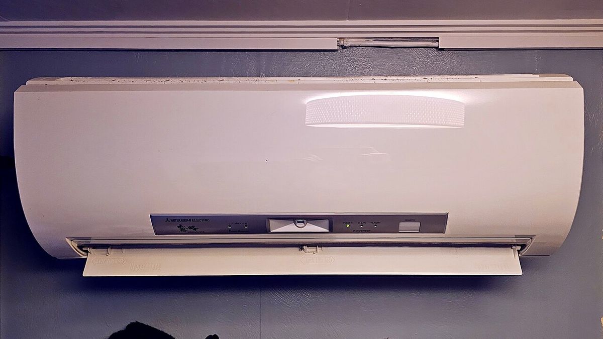 A ductless heat pump unit mounted high on a wall