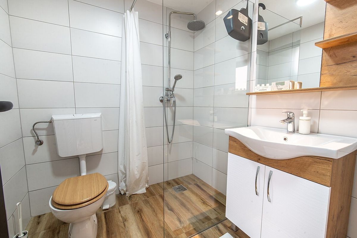 A clean bathroom with a walk-in shower and a white vanity
