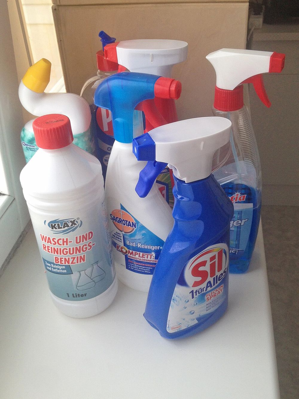 Spray bottles of cleaning products on a white counter