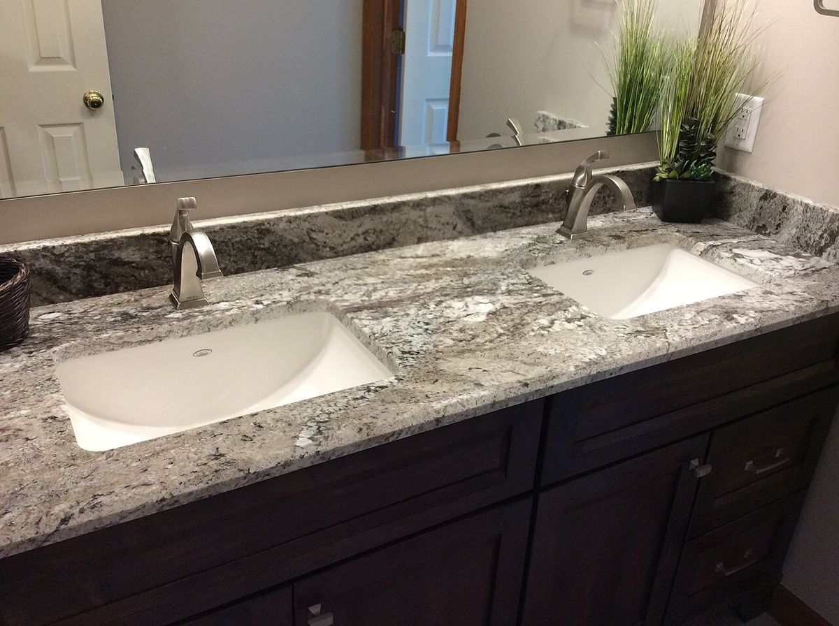 A double bathroom vanity with a granite counter and two sinks